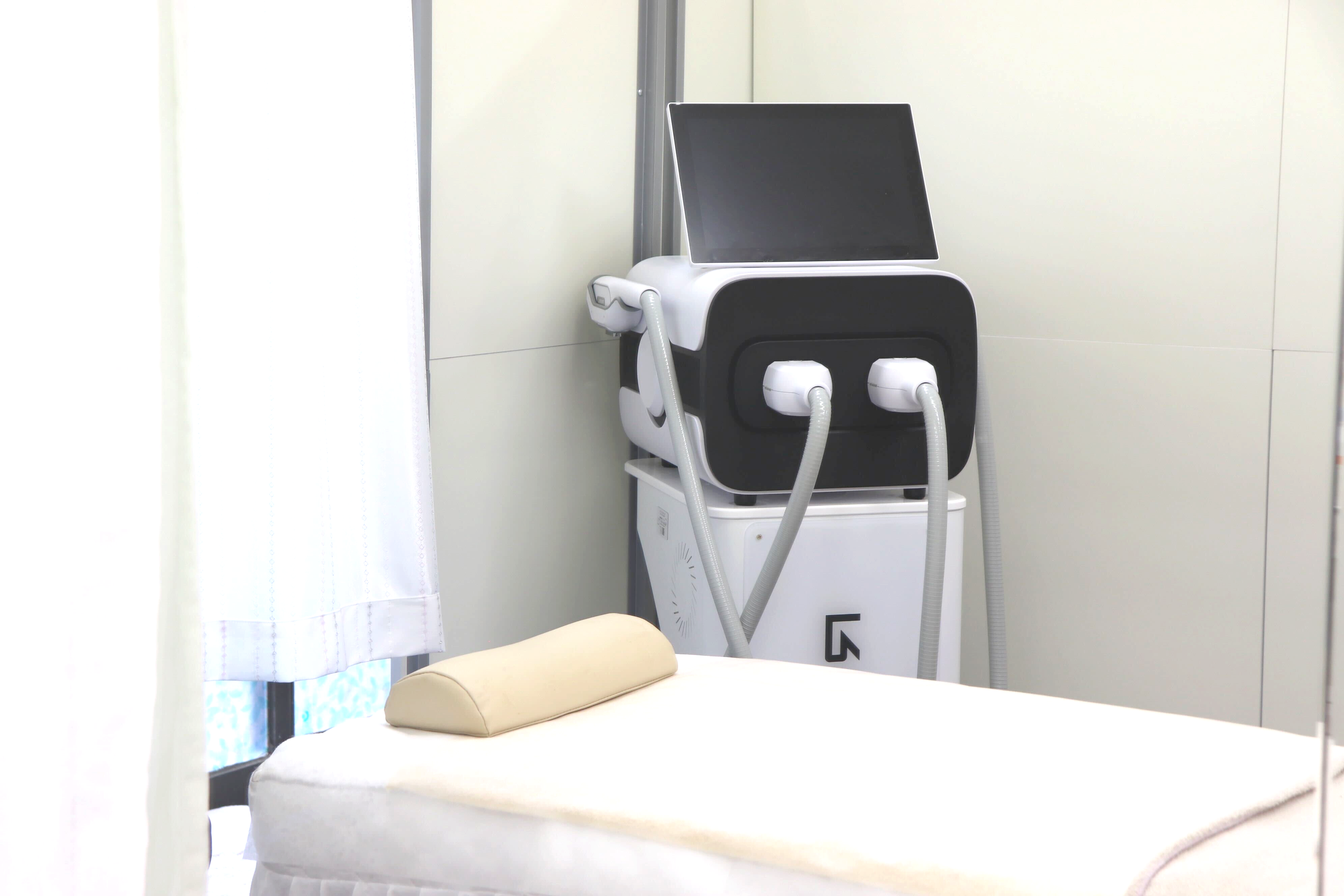 脱毛サロン【beauty salon ChaRme】の施術ルーム。脱毛機と施術ベッドが置かれた店内の様子