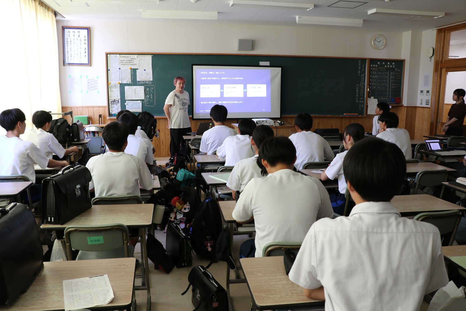 鹿児島中央高校の教室で、スライドを投影しながら高校生にピッチを行う里洋平